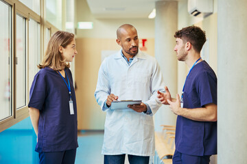 Medical team discussing patient chart in hospital corridor