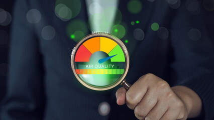 Hand holding a magnifying glass to check the good air quality at the green level safe from pollution dust PM 2.5.good air quality