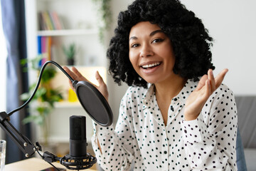 Happy woman recording a podcast from her home studio