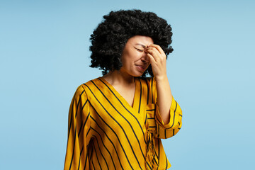 Young woman suffering from strong headache touching her face with hand