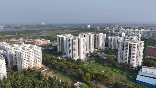 An aerial view of urban landscape with a mix of taller residential buildings, more modern structures in the background, indicative of commercial or high-rise residential developments.