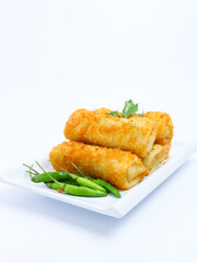 A plate of crispy golden vegetable risol served with green chili peppers and parsley garnish. isolated on white background. risol isolated