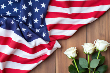 american flag and two white roses on a wooden table