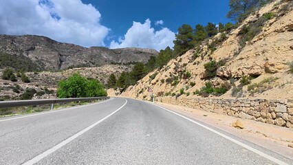 The beautiful and scenic mountain road winds through curves amidst a stunning natural landscape