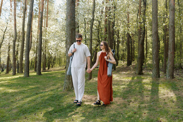 Fototapeta premium Couple enjoying a leisurely stroll through a scenic forest in springtime