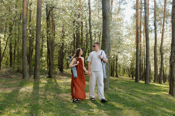 Fototapeta premium Couple enjoys a leisurely walk through a serene forest during springtime afternoon