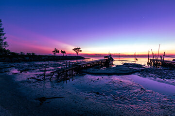 The natural background of the morning light by the sea, the local fishing pier in Ban Tha Sala, Nakhon Si Thammarat, has the beauty of the golden light of the sun.