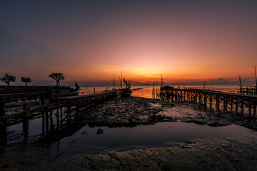 The natural background of the morning light by the sea, the local fishing pier in Ban Tha Sala, Nakhon Si Thammarat, has the beauty of the golden light of the sun.