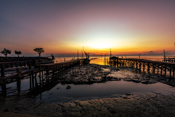 The natural background of the morning light by the sea, the local fishing pier in Ban Tha Sala, Nakhon Si Thammarat, has the beauty of the golden light of the sun.