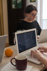 Three software developers brainstorming in a modern office. Team coding session with laptops...
