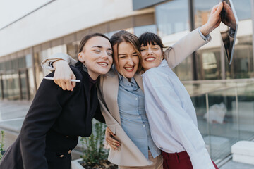 A group of three women embracing and laughing together outside. They exude positivity and collaboration, showcasing success and camaraderie among female entrepreneurs.