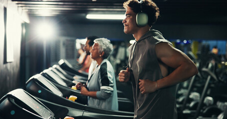 Fitness, man and running on treadmill with headphones at night for cardio, exercise and music....
