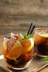 Refreshing Cuba libre cocktail with mint on wooden table. Space for text