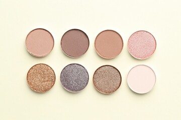 Beautiful eyeshadow refill pans on beige background, flat lay