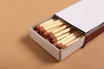 Matches in box on beige background, closeup