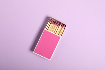 Matches in box on violet background, top view. Mockup for design