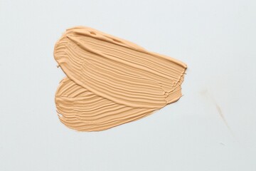 Sample of foundation on white background, top view