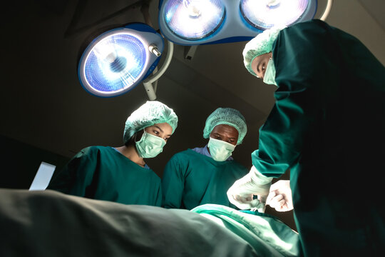Professional diversity surgery team serious working operating in operation room