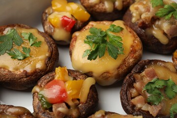 Tasty stuffed mushrooms in baking dish, closeup