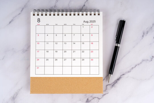 desk calendar august 2025 with pen on marble table, concept of schedule planning and time management