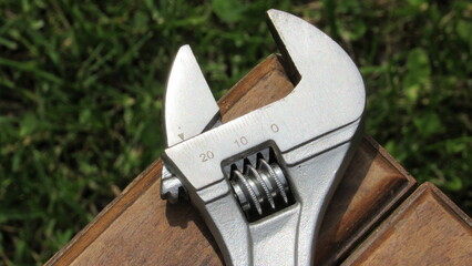 Tools resting on wooden surface after outdoor maintenance work in a garden during bright daylight