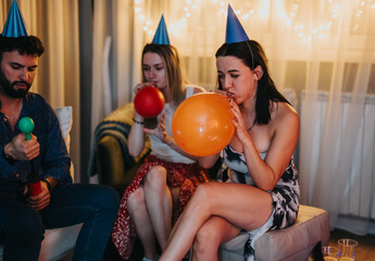 Friends preparing balloons during a cozy birthday celebration at home