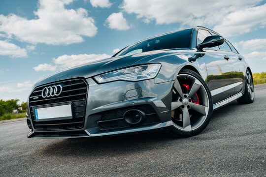 Audi A6 C7 Avant V6T S-Line Quattro parked in the countryside outside on a cloudy day. Top down front shot with gray alloy wheels on an empty asphalt road. Marketing, advertising or press articles.