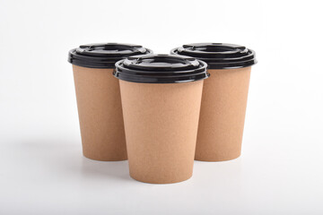 Three Brown paper coffee cup isolated on white background. Blank Kraft Coffee Cup for Takeaway