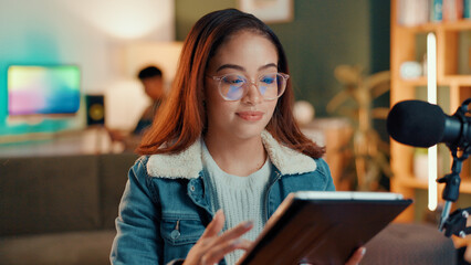 Woman, podcast and tablet in home with mic, smile and typing with script editing for video production. Gen z influencer, happy and app for chat, contact and subscription list on social media at house