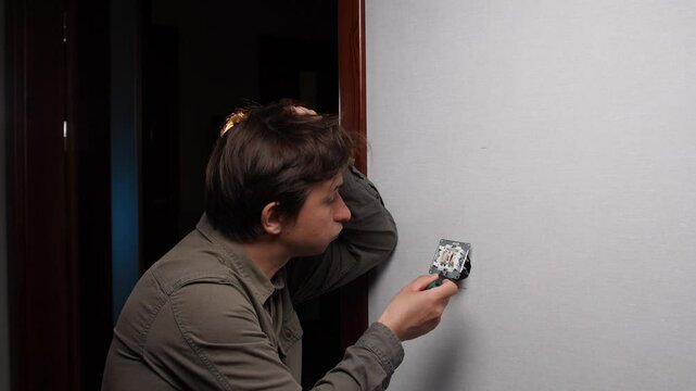 A man does not know how to fix the electrical wiring, a switch at home