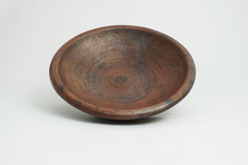 Side view of a traditional handmade clay plate with a rustic brown texture. Ideal for food styling, ethnic culinary themes, and natural kitchen props.