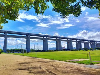 Fototapeta premium 夏空にそびえる瀬戸大橋と緑の広場
