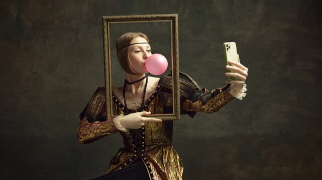 Animated portrait of pretty young girl, looks as princess with bubble gum, holding picture frame and taking selfie with smartphone against vintage background. Concept of history, renaissance art