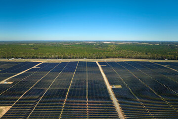 Aerial view of large sustainable electrical power plant with rows of solar photovoltaic panels for...