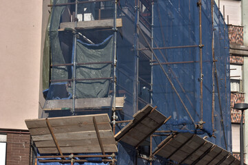 Ponteggio con teli di protezione blu su cantiere edile per ristrutturazione facciata