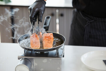 chef cooking salmon steaks in the kitchen