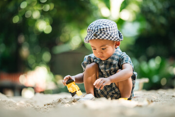 Curious toddler playing with sand outdoors, developing fine motor skills, creativity, and cognitive growth through hands-on exploration in a safe, natural learning environment under sunlight