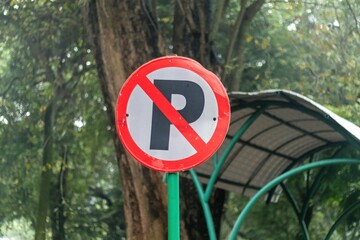 No parking sign with lush trees in background