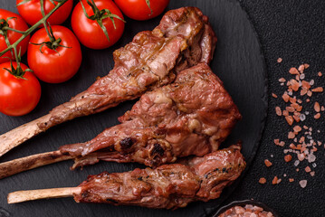 Juicy meat on the bone or rack of lamb. Grilled veal with salt, spices and herbs