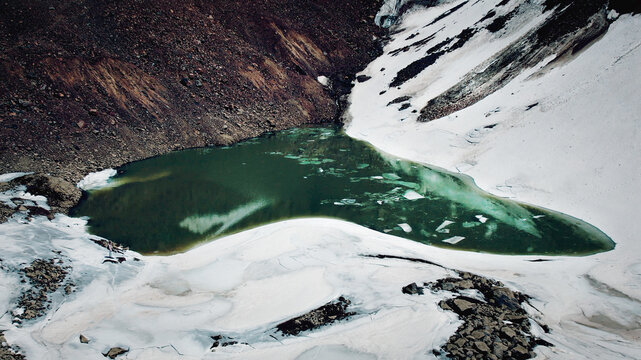 A panoramic view of a moraine Lake number 6 (Manshuk Mametova) in Almaty, Kazakhstan nested among rugged snow-capped mountains