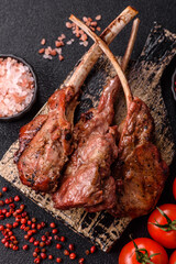 Juicy meat on the bone or rack of lamb. Grilled veal with salt, spices and herbs