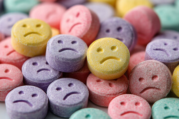 pile of pills with sad face imprint, drug themes