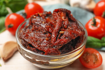 Delicious sun dried tomatoes and fresh vegetables on white table, closeup