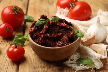 Tasty sun dried tomatoes and fresh vegetables on wooden table, closeup