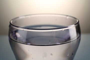 Fresh water in glass on gray gradient background, closeup