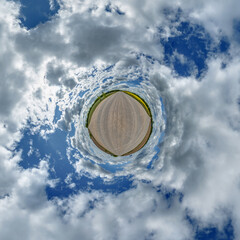 simple little tiny planet without buildings in blue sky with sun and beautiful clouds. Transformation of spherical panorama 360 degrees. Spherical abstract aerial view. Curvature of space.