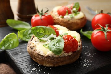 Tasty stuffed mushrooms served on wooden table, closeup