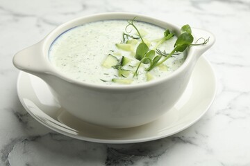Tasty cucumber soup with dill and microgreens on white marble table, closeup