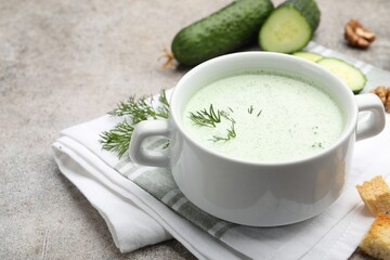 Tasty cucumber soup with dill, croutons, walnuts and vegetables on grey table, closeup
