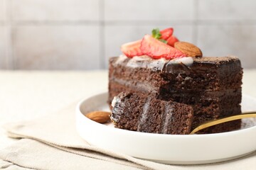 Piece of delicious chocolate cake with strawberry and almonds on table, closeup. Space for text